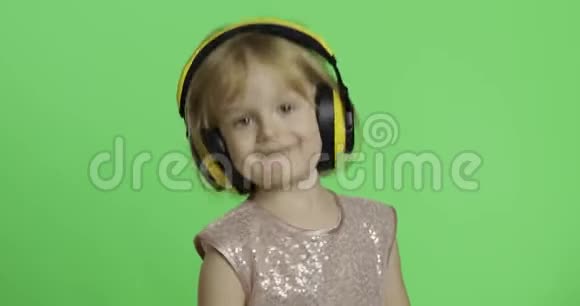 女孩穿着光滑的衣服和耳机听音乐和跳舞铬键视频的预览图