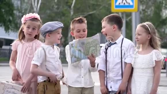 小孩子在一个复古和带纸卡的成本衣服和街头谈话孩子们争论一些事情视频的预览图