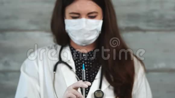 一位年轻的护士用装满药品的注射器释放空气视频的预览图