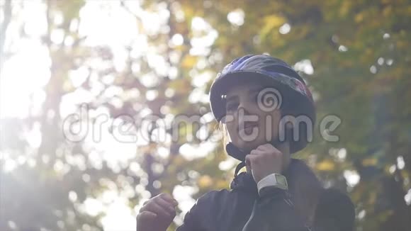 秋天公园里骑自行车的年轻女子近距离拍摄慢动作阳光背景视频的预览图
