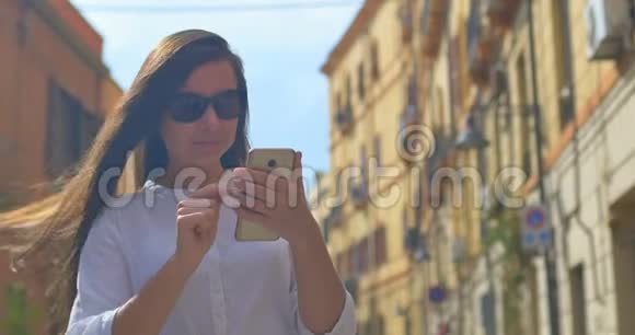 欧洲城市的年轻美女使用智能手机视频的预览图