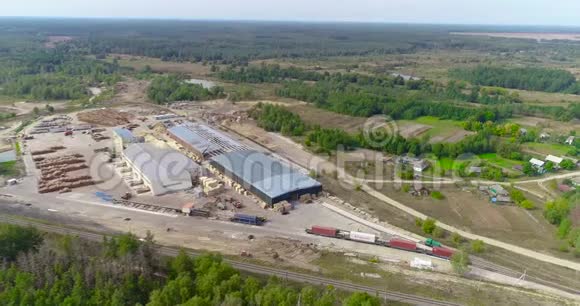 一个大型锯木厂位于森林地区的鸟瞰图现代化的木工工厂与铁路交汇处视频的预览图
