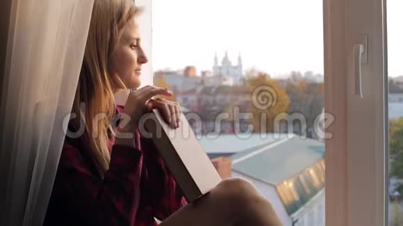梦中的年轻女子坐在家里的窗台上看书视频的预览图