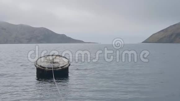 在多云的山地背景下在海水中航行的大桶船视频的预览图