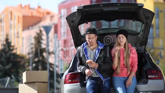 微笑的夫妇坐在现代汽车的后备箱里视频的预览图