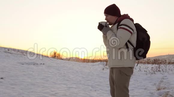 日落时分年轻人在山上喝热茶或热水瓶咖啡视频的预览图