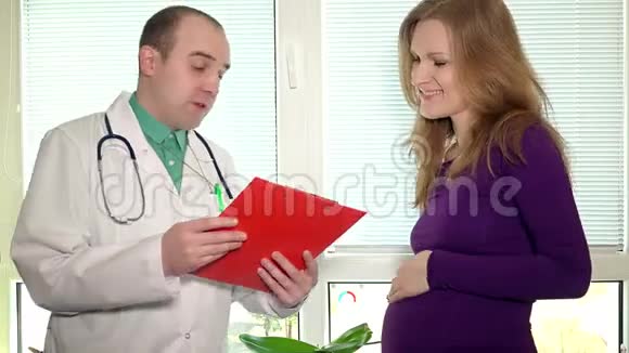 注意男性医生与孕妇谈论测试结果和握手视频的预览图