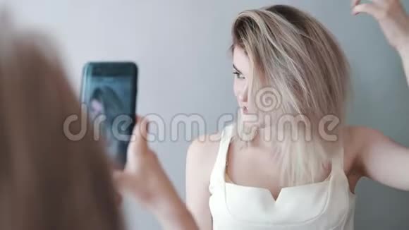 化妆师在电话里给模特拍照深唇灰色背景化妆视频的预览图
