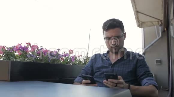 一个人在咖啡馆里用两部手机工作视频的预览图