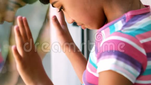悲伤的女孩站在窗边视频的预览图