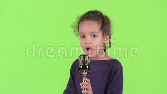 一个穿着复古麦克风唱歌的非裔美国女孩的孩子绿色屏幕视频的预览图