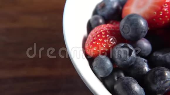 草莓和蓝莓放在白碗里准备吃视频的预览图