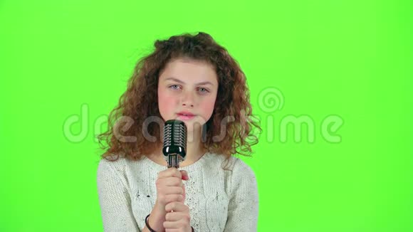 小女孩用复古麦克风唱火辣辣的歌绿色屏幕视频的预览图