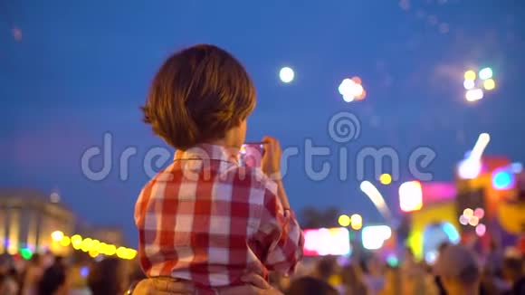 小男孩幼儿拍摄美丽烟花的图片在夜空中展示手机宝宝的手视频的预览图