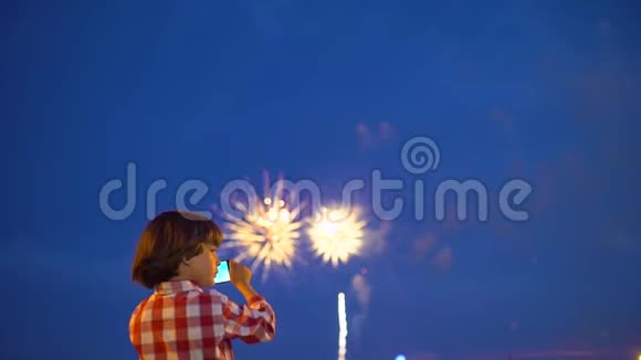 小男孩幼儿拍摄美丽烟花的图片在夜空中展示手机宝宝的手视频的预览图
