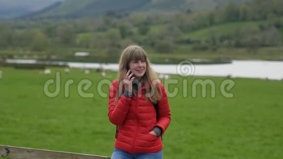 年轻女子站在典型的爱尔兰风景中打电话视频的预览图