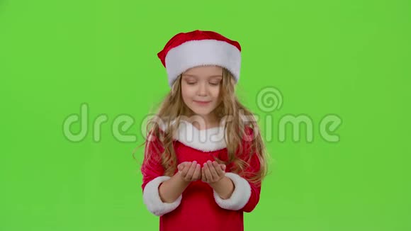 穿着圣诞服装的小女孩膨胀了恒星花粉绿色屏幕慢动作视频的预览图