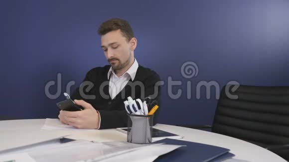 这位商人用电话在办公室写文件视频的预览图