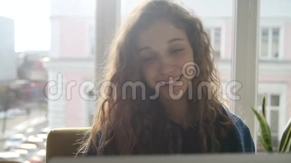 女人在窗户附近浏览笔记本电脑视频的预览图