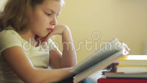 一个女学生坐在桌子旁看书家庭教育儿童教育知识日视频的预览图