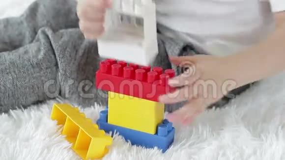 这孩子手是用白色背景上的彩色积木演奏出来的视频的预览图