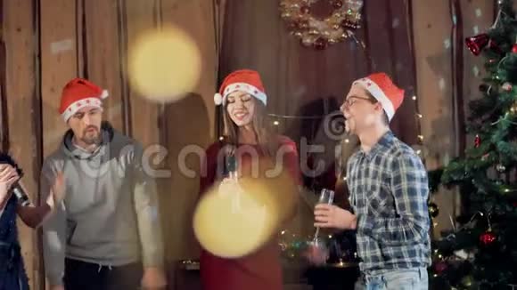 在新年晚会上年轻人戴着圣诞帽跳舞唱歌慢动作4K视频的预览图