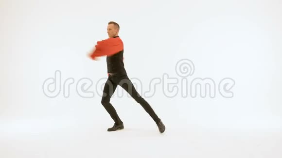 一个穿着黑色西装和红色衬衫的年轻人在白色背景上跳舞很漂亮视频的预览图