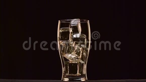 可乐倒入一个玻璃与冰它泡沫形成泡沫帽黑色背景视频的预览图