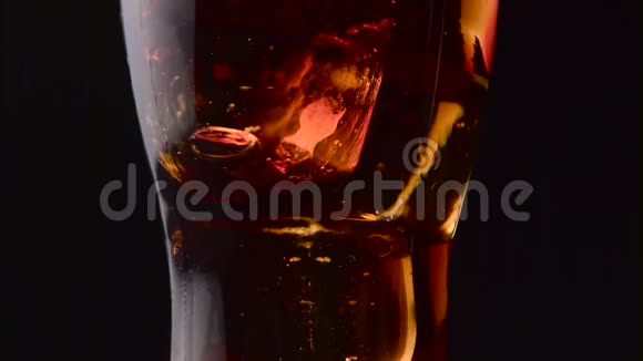 在黑色背景下用玻璃喷射气体使百事可乐加冰关门视频的预览图
