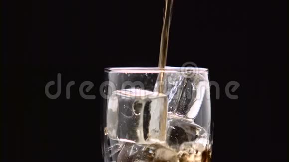 可乐倒入玻璃与冰块它溢出泡沫流过边缘黑色背景关门视频的预览图