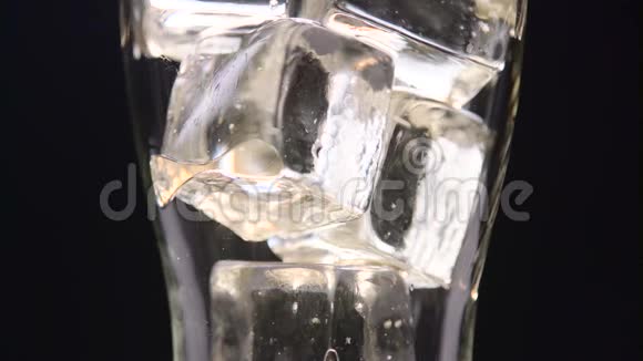 可乐装满了一个装满冰块的透明玻璃黑色背景关门视频的预览图
