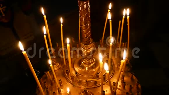 在基督教东正教教堂的其他蜡烛背景上点燃蜡烛特写视频的预览图