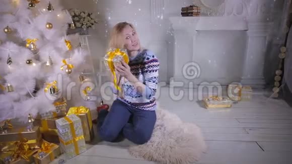 一个年轻的女人摇圣诞礼物视频的预览图