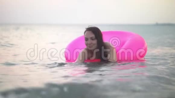 海浪把女孩压在一个充气的圆圈上视频的预览图