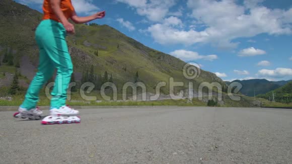 溜冰在行走的小路上内排滑冰鞋中女性腿的特写镜头慢动作高清高清视频的预览图