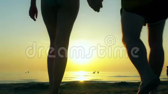 快乐的一对夫妇沿着海滩朝大海走去视频的预览图