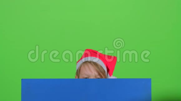 小男孩从一张蓝色的海报后面出现看着他摇了摇头又躲了起来绿色屏幕视频的预览图