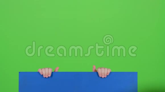 戴着帽子的少年站起来双手握着绿色屏幕上的木板视频的预览图