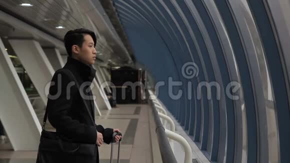 英俊的韩国男子正走在机场大楼的室内视频的预览图