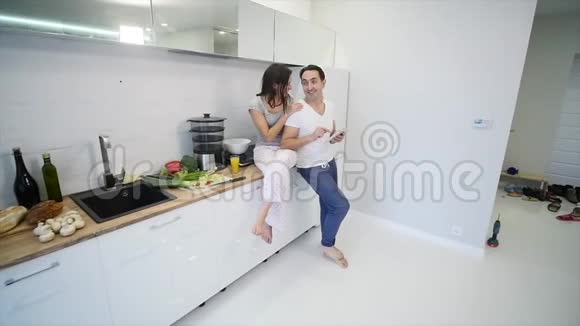 在家厨房里有平板电脑的幸福夫妇慢动作视频的预览图