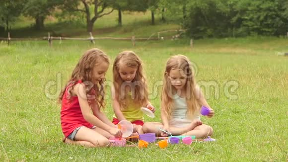 三个女孩在大自然中玩玩具慢动作视频的预览图
