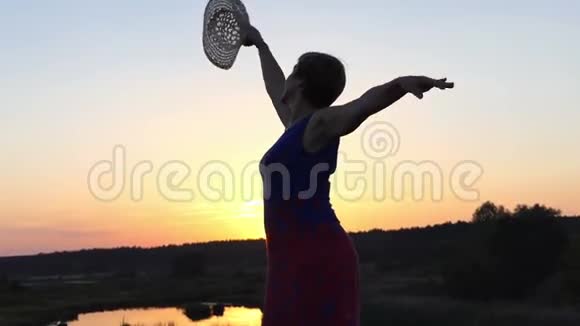 日落时分中年妇女在湖岸上跳舞视频的预览图