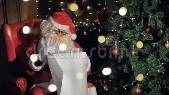 特写圣诞老人在圣诞壁炉附近读信4K视频的预览图