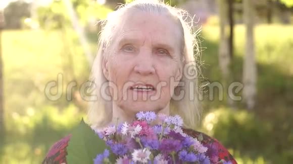 公园里有一束花的老妇人视频的预览图
