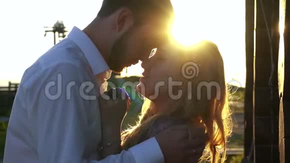 英俊的年轻人温柔地抚摸着他的爱人的脸在日落时亲吻她近距离敏感视频的预览图