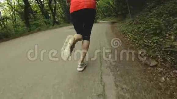 跑步女孩金发女孩在夏天的森林里做户外运动后视慢动广角特写镜头视频的预览图