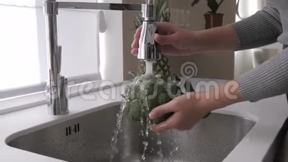 女孩在厨房水槽里洗花椰菜视频的预览图
