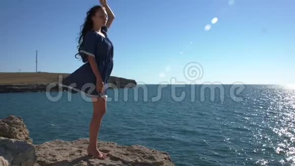 穿着蓝色连衣裙站在海边的女孩视频的预览图