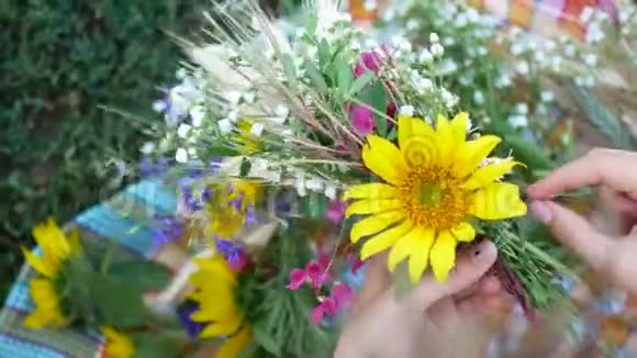 女性的双手构成夏日野花的花环视频的预览图