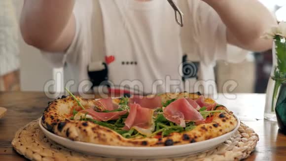特写厨师在美味的比萨饼上烤奶酪特写意大利火腿视频的预览图